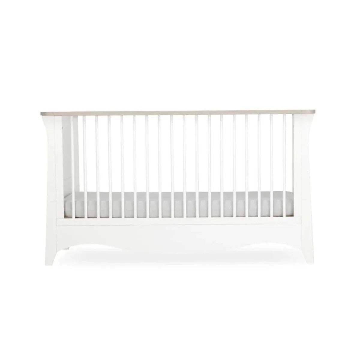 White cot bed with vertical slats and a curved lower front panel