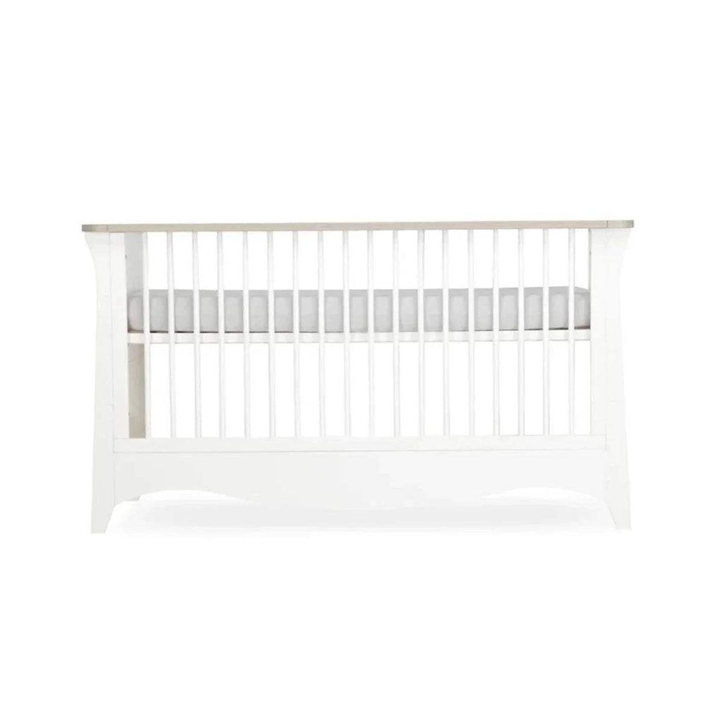 White cot bed front view with vertical slats and curved lower base