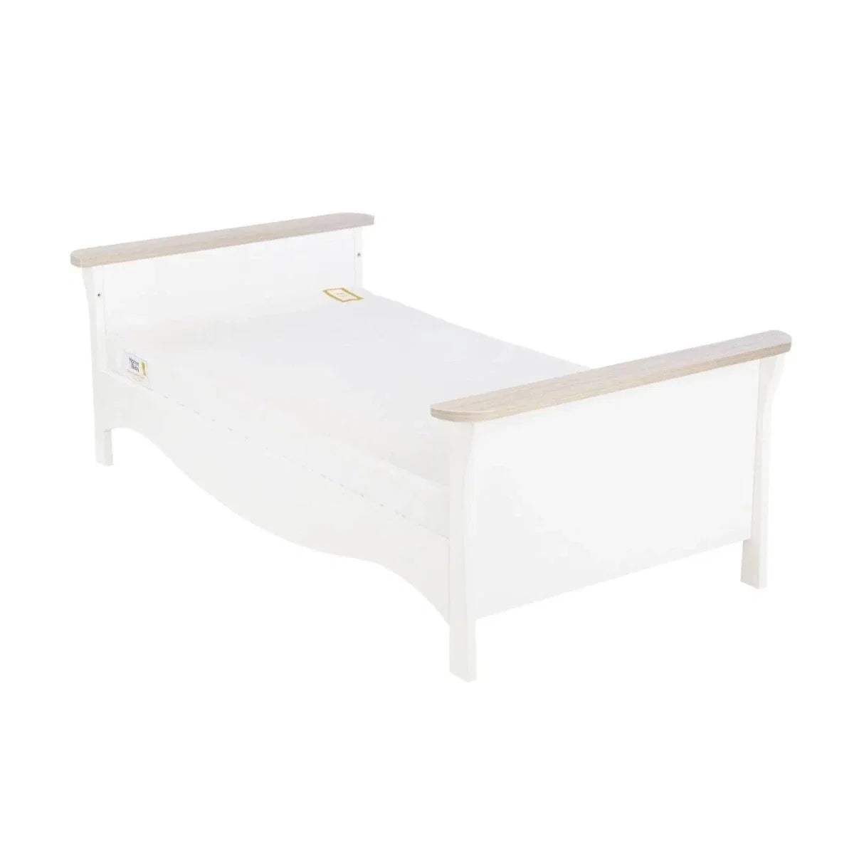 White cot bed with pale ash-toned end rails and mattress surface