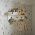 White kids wall shelf with top ledge, 3 round knobs, and hanging rail for clothes