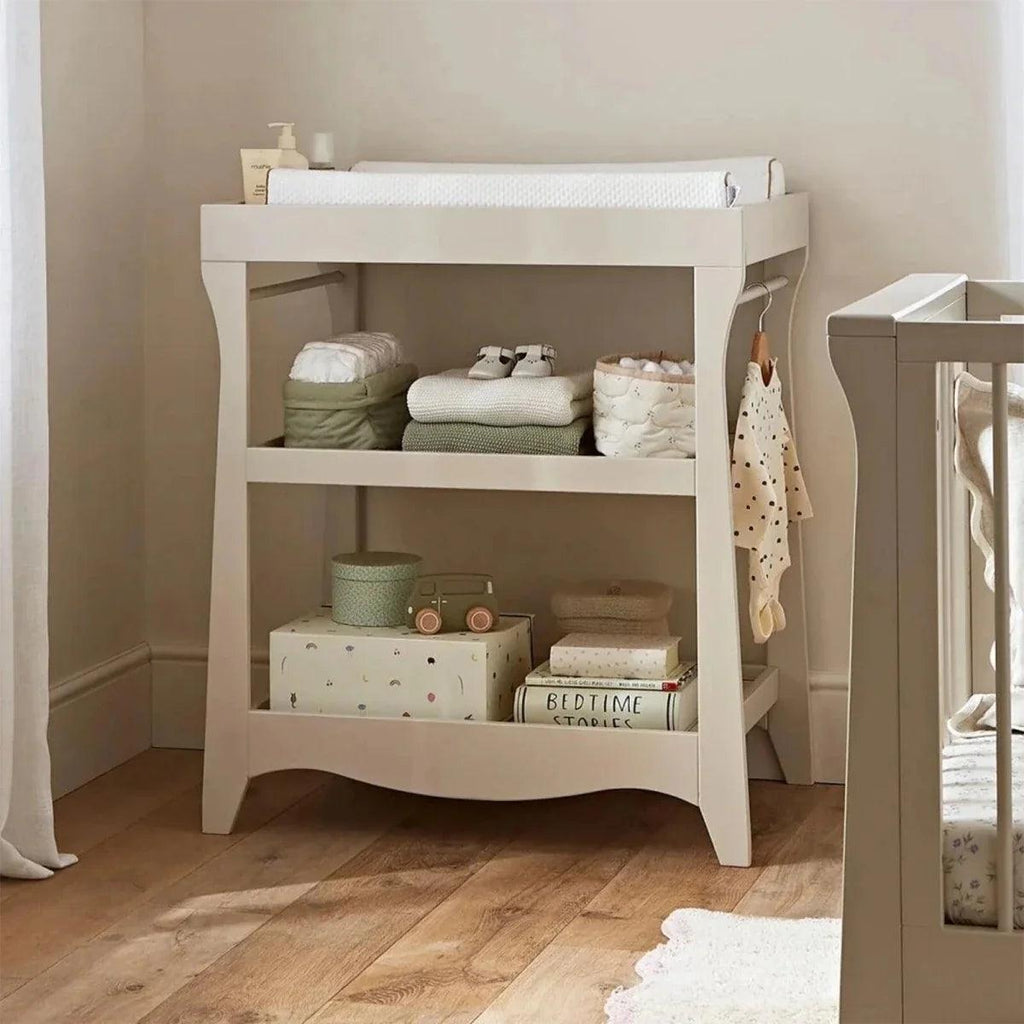 White mini baby changing table with open shelves and raised top sides