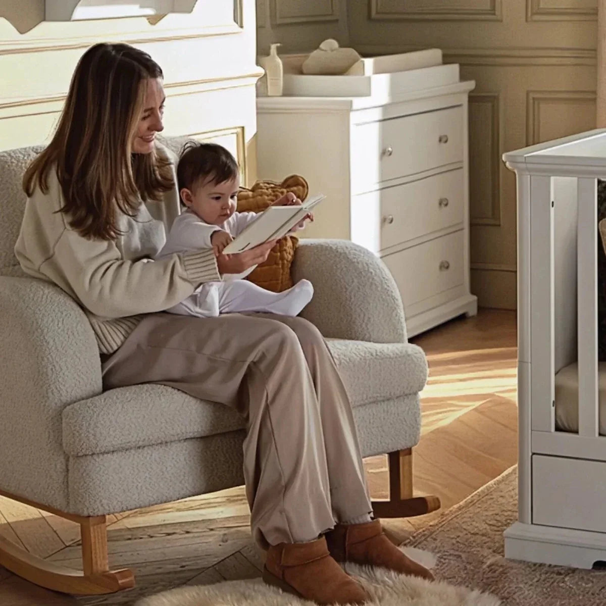 Light beige boucle nursing chair with matching ottoman, shown with adult and child