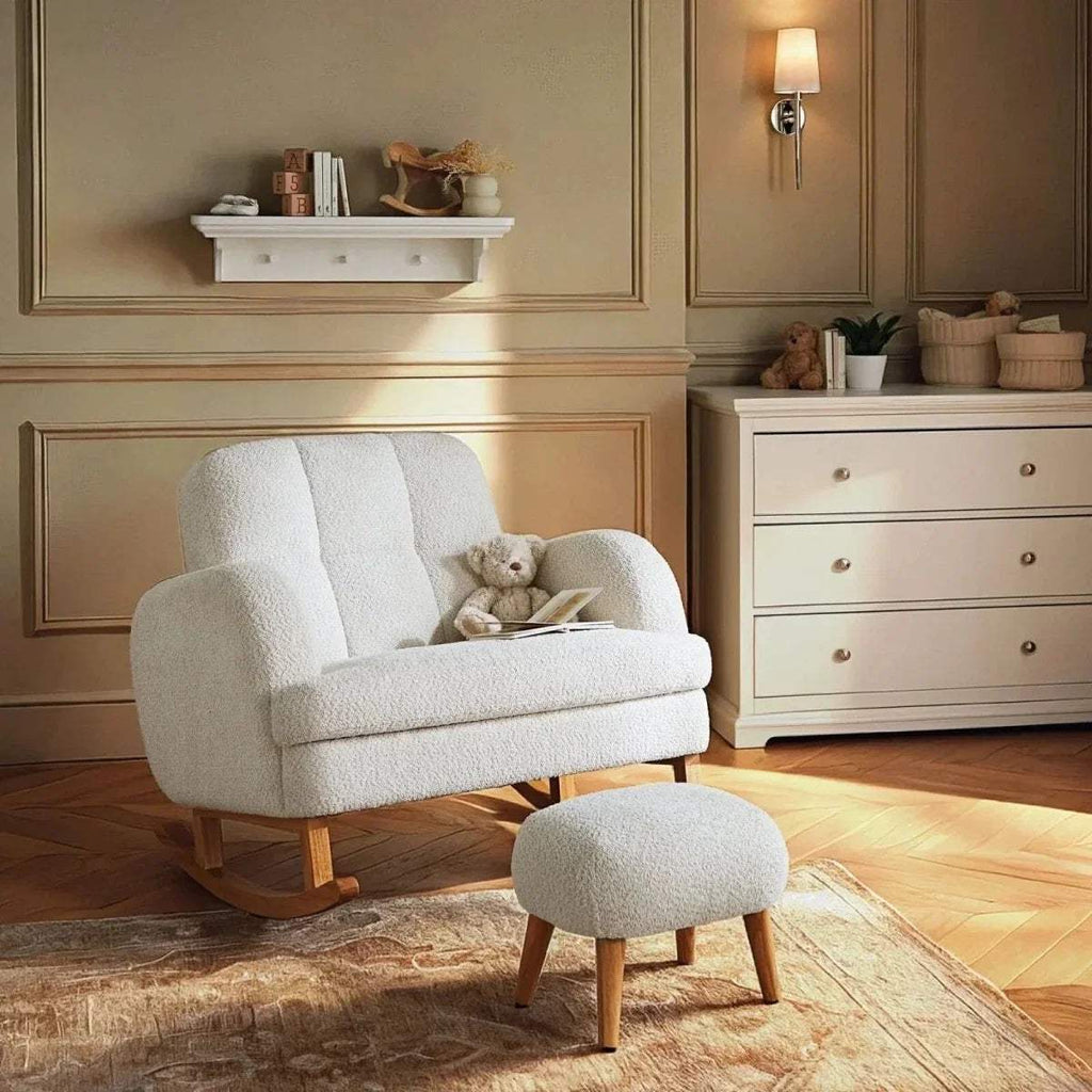 Off-white boucle nursing chair with curved wood base and matching round foot stool
