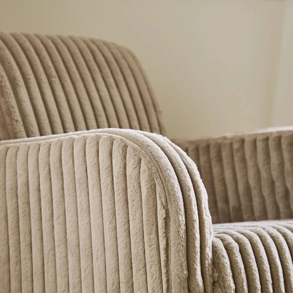 Close-up of mink ribbed faux-fur nursing chair arm and backrest with rounded padded edges.