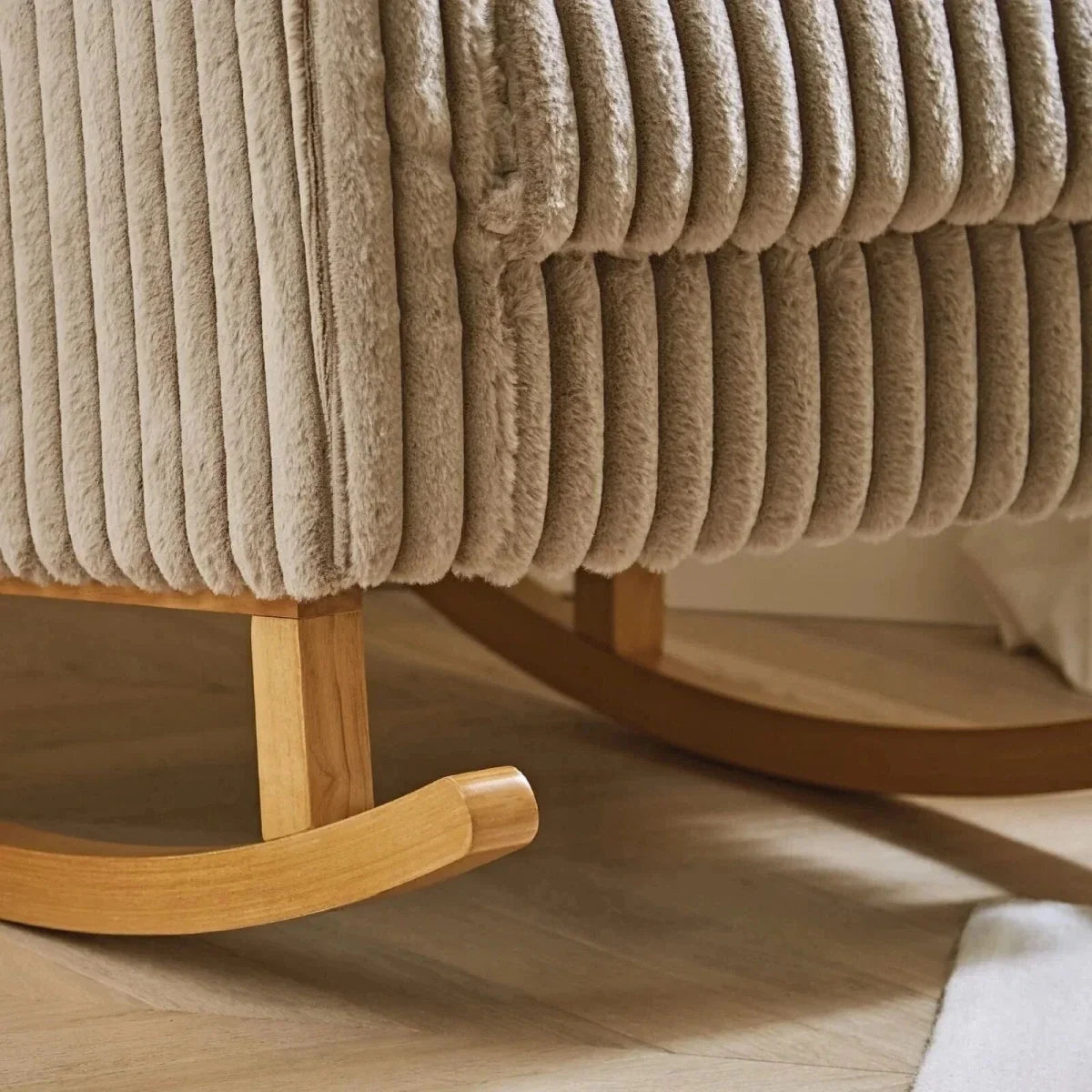 Mink ribbed faux-fur chair base and footstool with wooden rockers and upholstered trim.