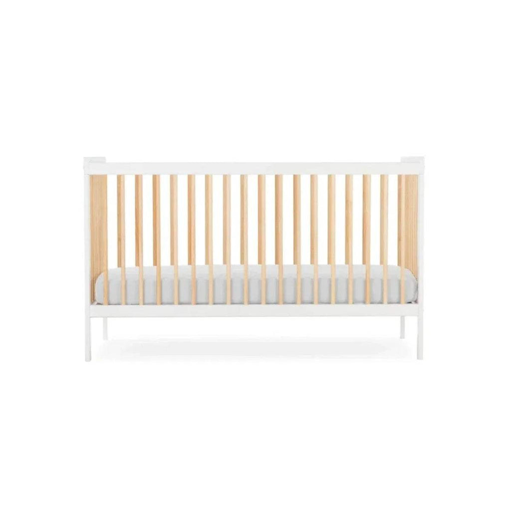 White cot bed with natural wooden slats and light grey padded mattress insert, front view.
