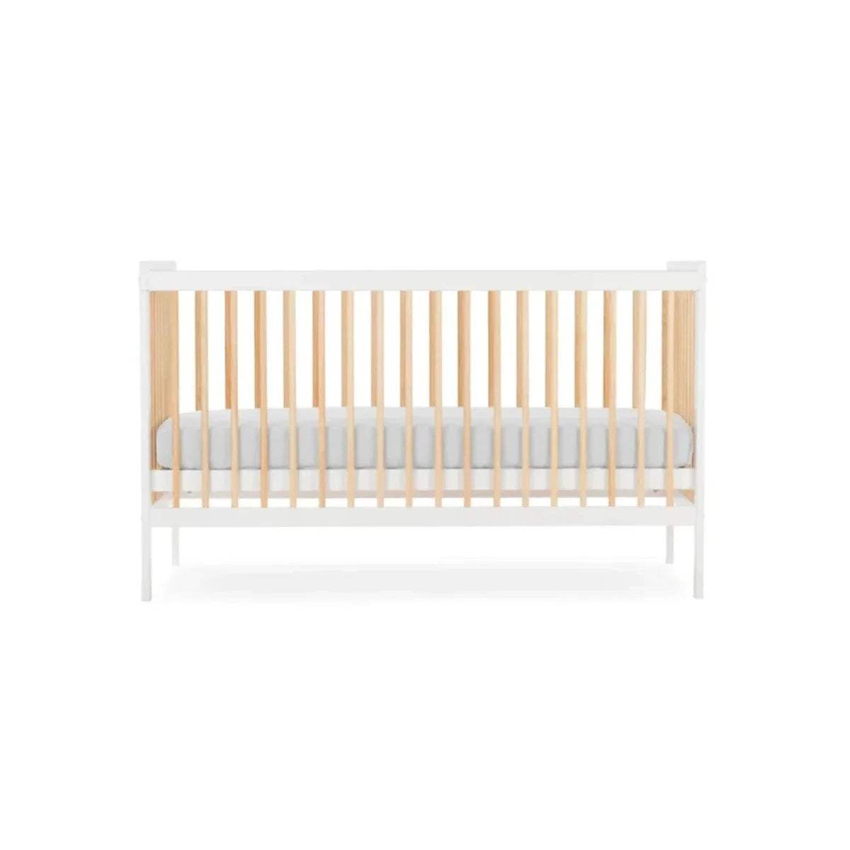 White cot bed with natural slatted rails and light grey mattress insert, angled view.