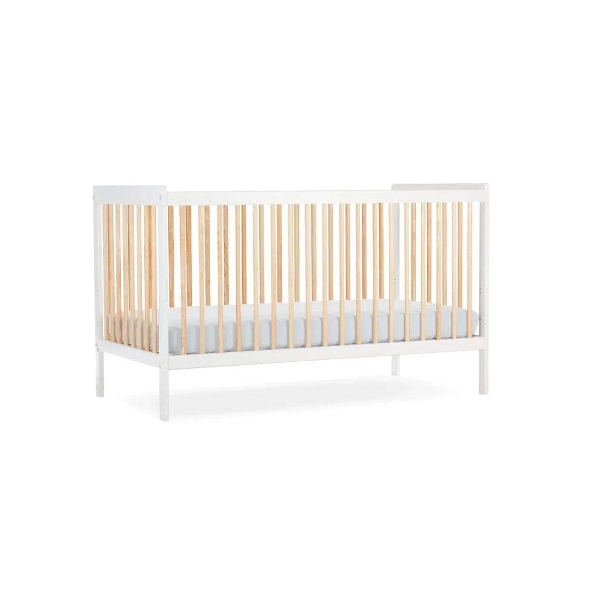 White cot bed with natural slats and light grey mattress insert, three-quarter view.