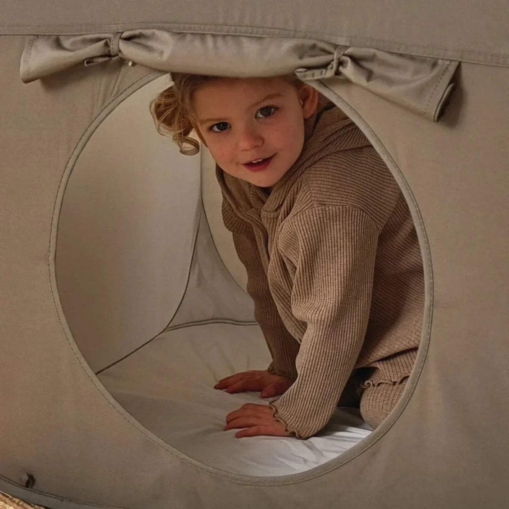 Gray tunnel end with round entrance and beige-and-tan striped fabric panel