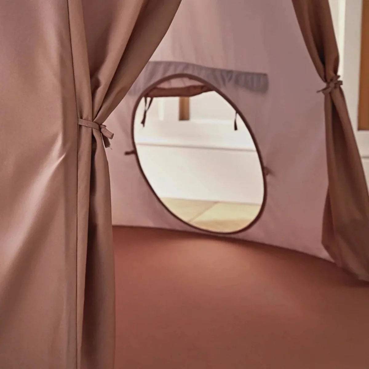 Dusty pink play tent panel with round window opening and tied fabric curtains