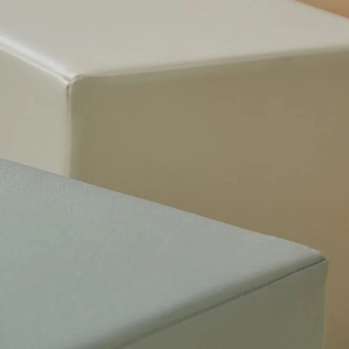 Close-up of smooth faux leather-style corner on sea salt and pebble play cubes
