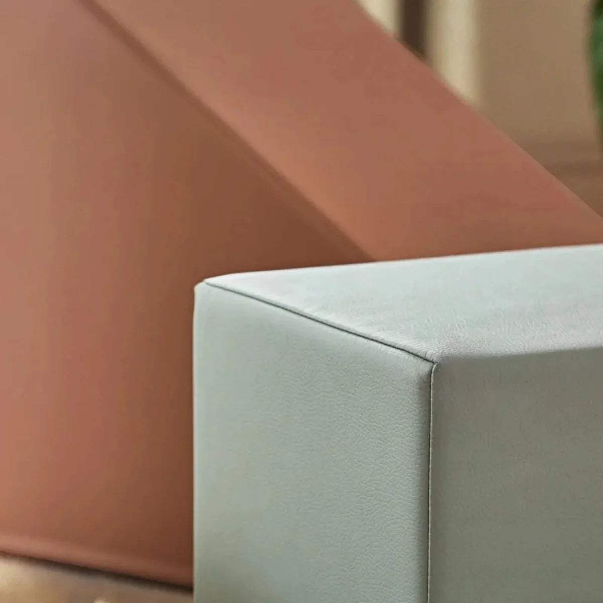 Padded foam play block corner seam with gray upholstery and brown ramp edge