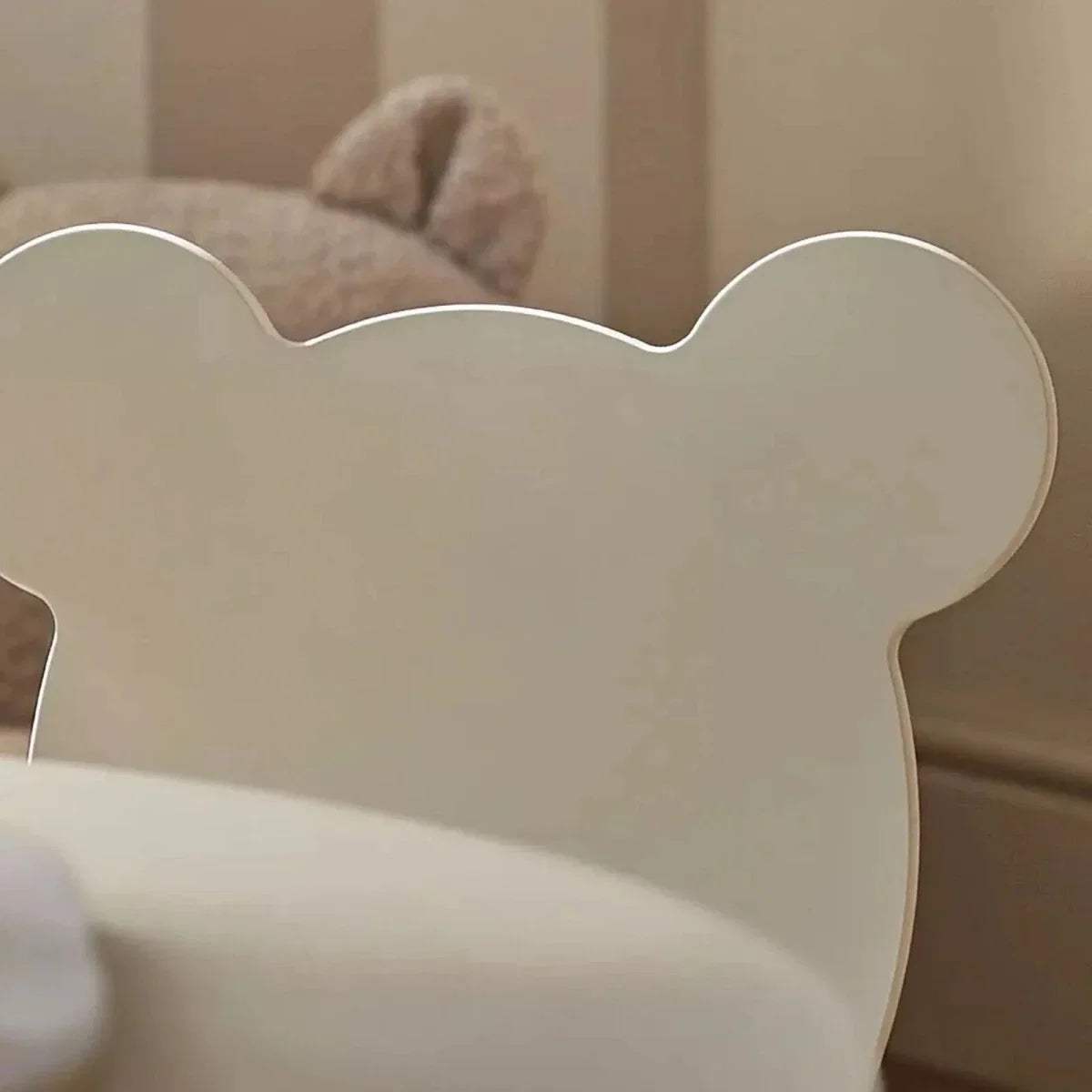 Close-up of white bear-shaped chair backrest with rounded ears and cutout detail
