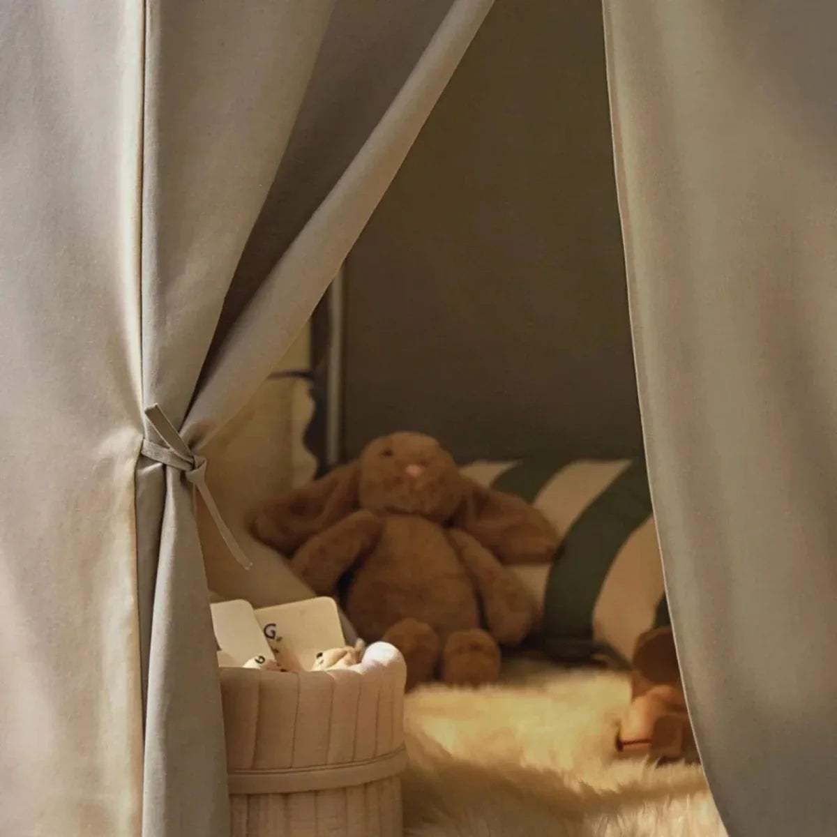 Inside view of sea-salt play tent with open side panels and plush toys on floor
