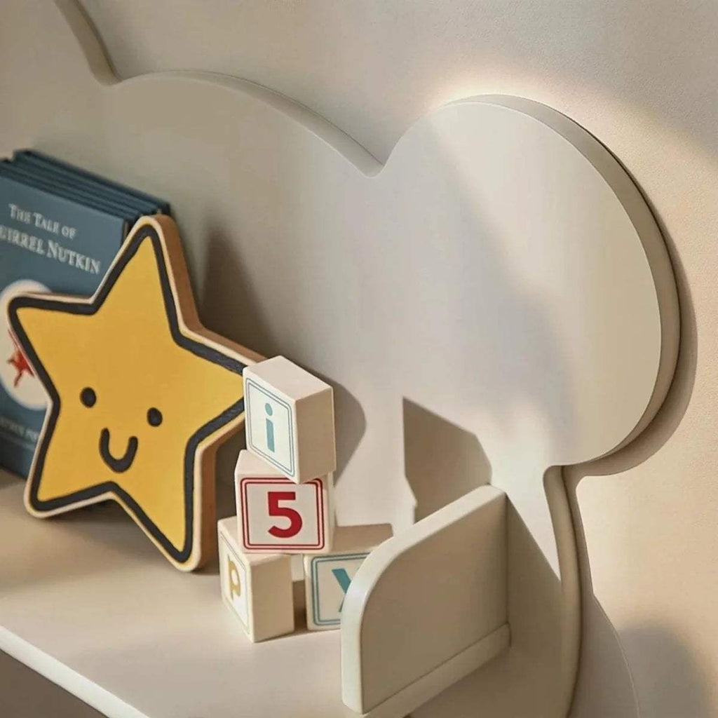 Pebble beige bear wall shelf with three round pegs, open cubby holding toys