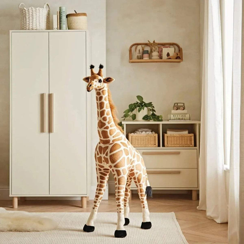 Standing plush giraffe stuffed animal with brown-and-cream print and black feet.