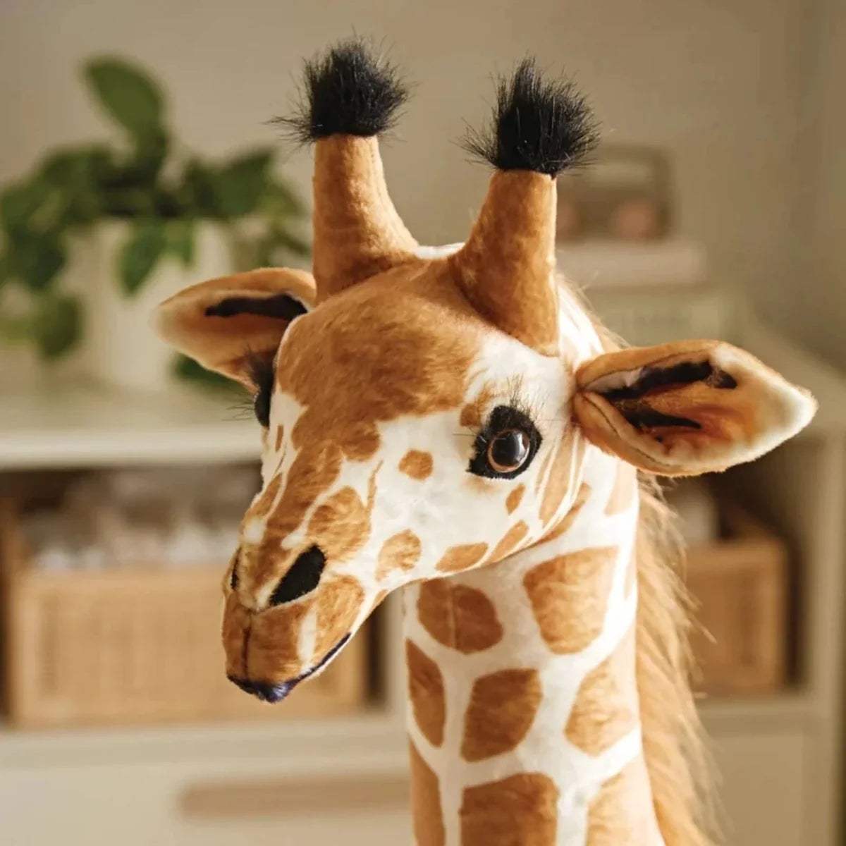 Close-up plush giraffe head with stitched eyes, brown-and-cream patch pattern, soft ears.