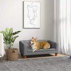 Grey dog sofa bed with tufted backrest and cushioned seat; small dog resting on it