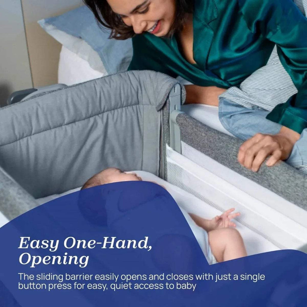 Dark gray bedside crib with white mattress and side panel opening