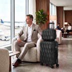 Black quilted hard-shell spinner suitcase standing upright on four wheels.