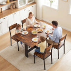 Rustic brown dining table with dark legs, set with dinner plates for four
