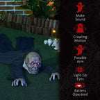Crawling zombie Halloween decoration on grass with glowing red eyes and posed arms