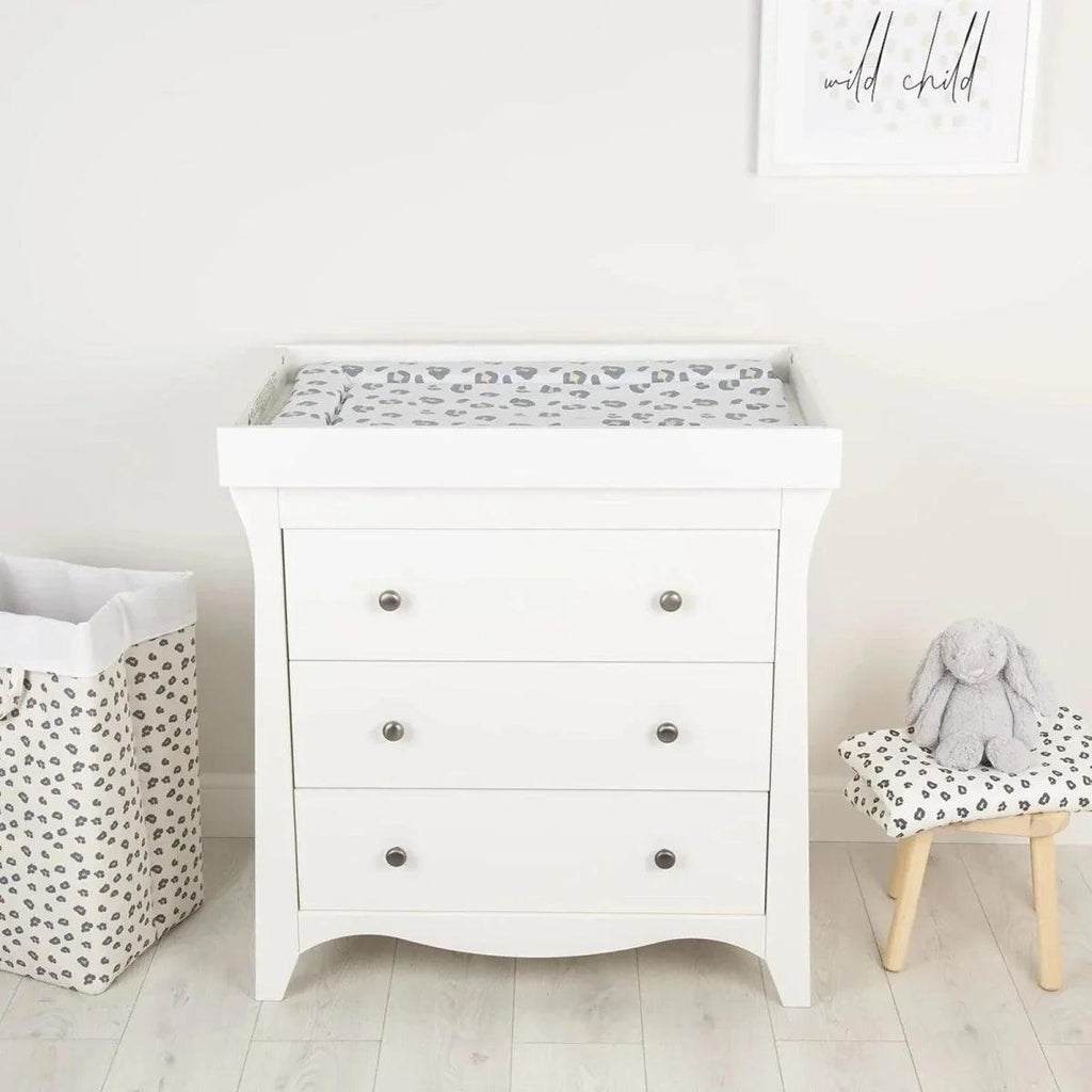 Muted leopard changing mat on a white dresser drawer for baby changing