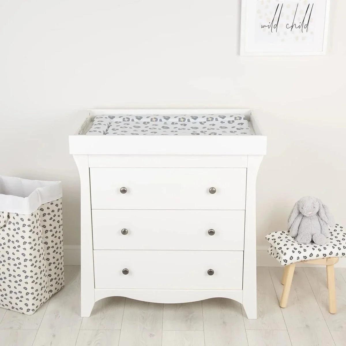 Muted leopard changing mat on a white dresser drawer for baby changing