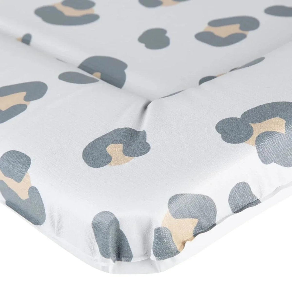 Muted leopard print changing mat fabric close-up with blue-gray and tan spots