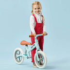Light blue kids balance bike with orange grips and brown seat, shown with a child