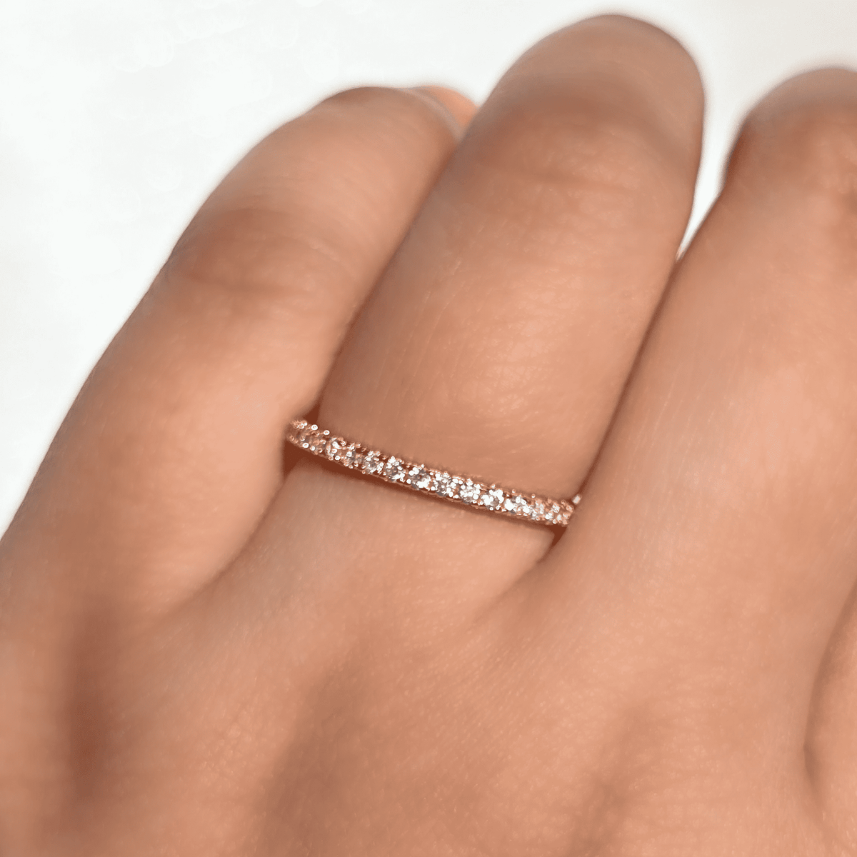 Thin gold vermeil eternity ring with pavé stones on finger