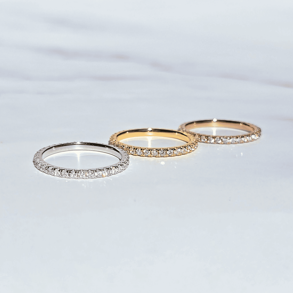 Three slim eternity rings with pavé stones in silver, gold, and rose gold
