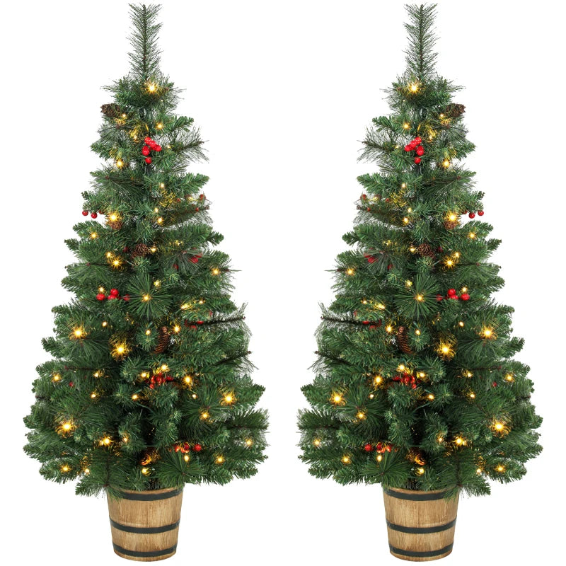 Two prelit green Christmas trees in pots with pinecones, berries, and warm white LED lights