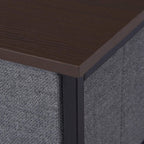 Corner of dark grey fabric drawer dresser with particleboard top and black metal frame.