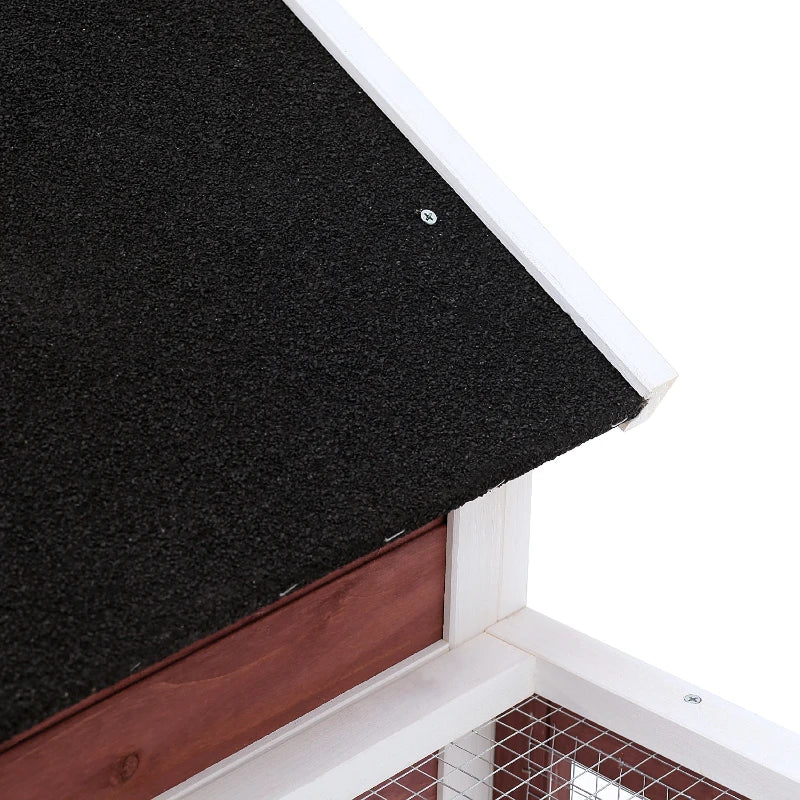 Black asphalt roof panel with white edging on maroon-and-white rabbit hutch