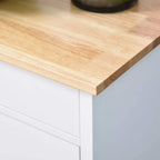 Light wood tabletop corner on a white kitchen trolley cabinet