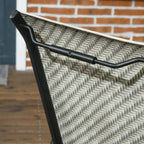 Close-up of mixed grey woven rattan seat and back with black armrest frame