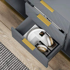 Grey sideboard drawer open with gold handle, holding magazines and small items