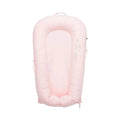 Pink fabric infant dock with raised rim, padded base, and side handles