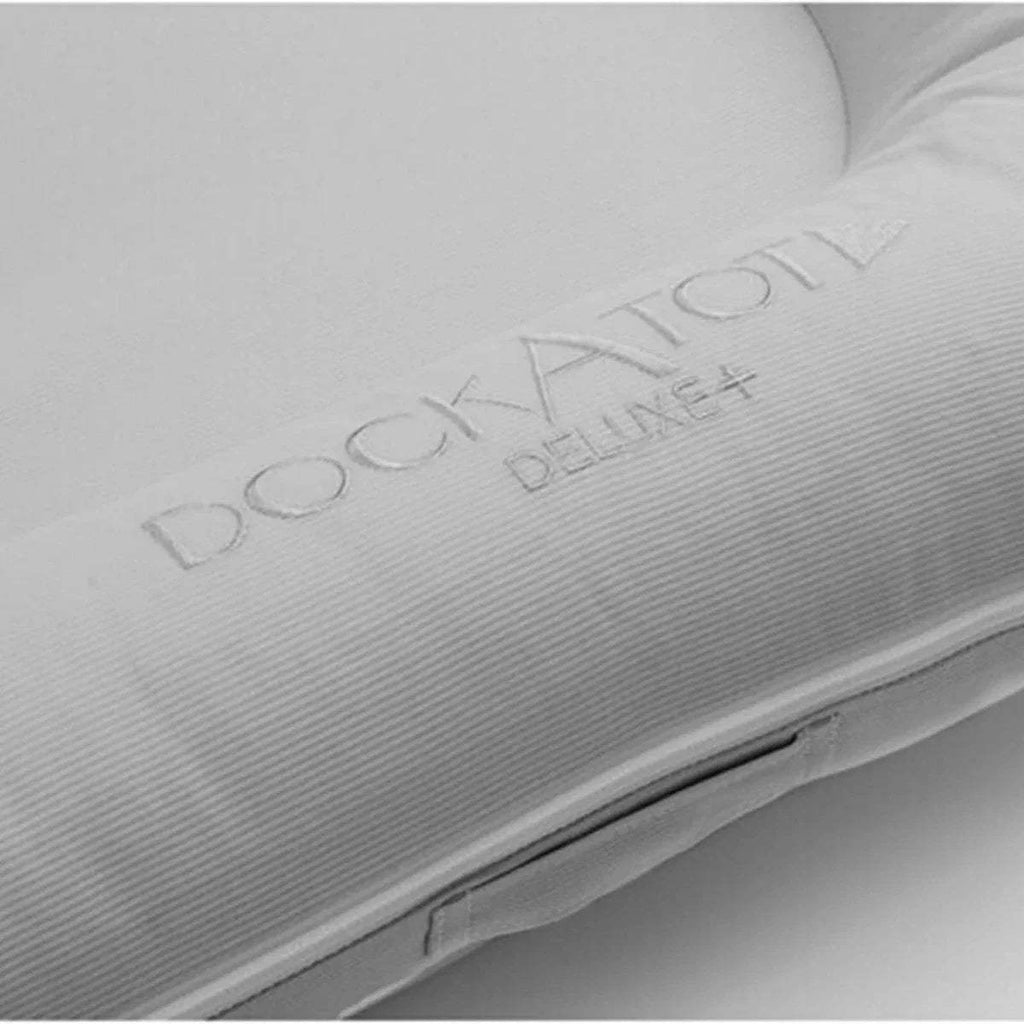Light gray fabric side panel with embossed DockATot logo