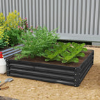 Square raised garden bed with dark grey metal frame, filled with soil and greens