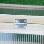 Metal hinge on wooden cold frame greenhouse lid with polycarbonate panel edge