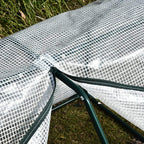 Close-up of white mesh cover secured to green greenhouse frame with straps