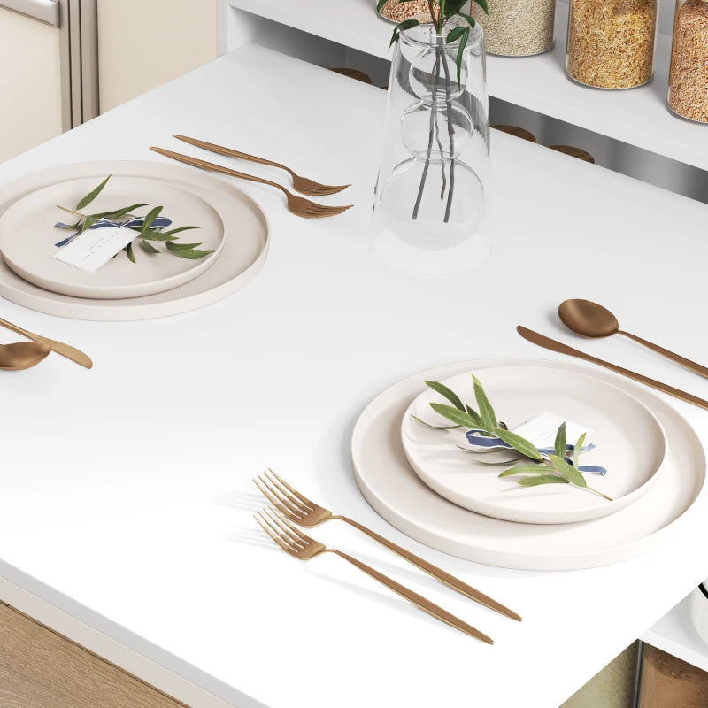White drop-leaf folding dining table top set with plates, cutlery, and a glass carafe