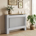 Grey radiator cover cabinet with vertical slat grill, light wood top shelf, cut-out sides