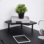 Black corner desk tabletop with raised edge and central support post.