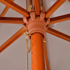 Parasol center hub with orange frame, rope pulley, and hanging chain attachment.