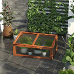 Small wooden cold frame greenhouse with transparent cover on outdoor floor