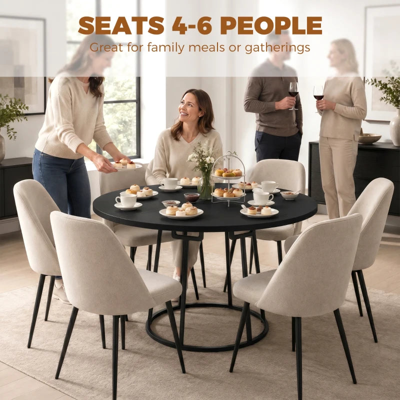 Round black dining table with central conical metal base in dining room