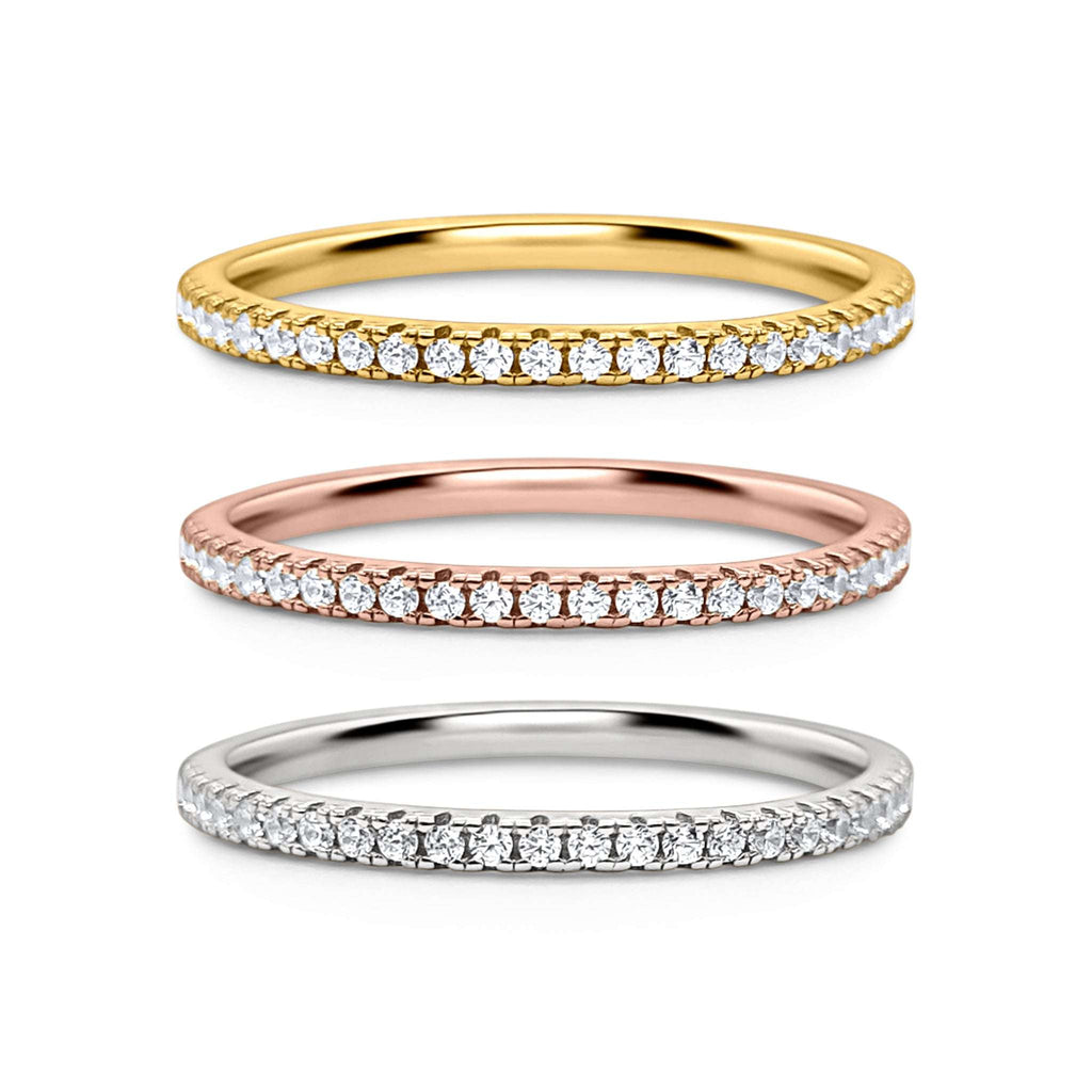 Three eternity stacking rings in yellow gold, rose gold, and silver with pavé stones